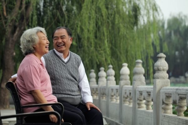 man and woman laughing on a bench