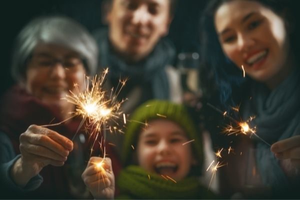 family with sparklers asking questions about new years
