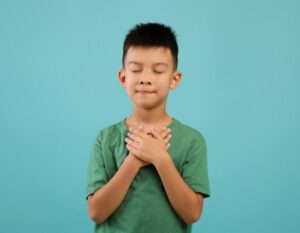 boy hands on heart: best kindness quotes for kids and for school