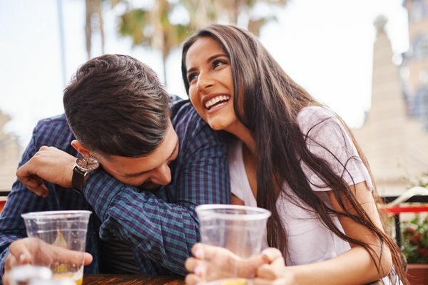 man and woman having fun and drinking together