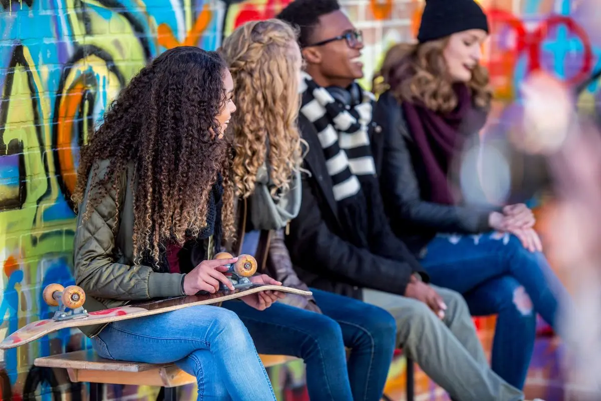 teenagers sitting by a colorful wall