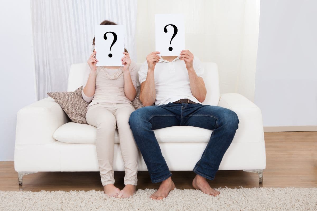 couple sitting on couch holding question marks; classy  him or her Mr and Mrs questions