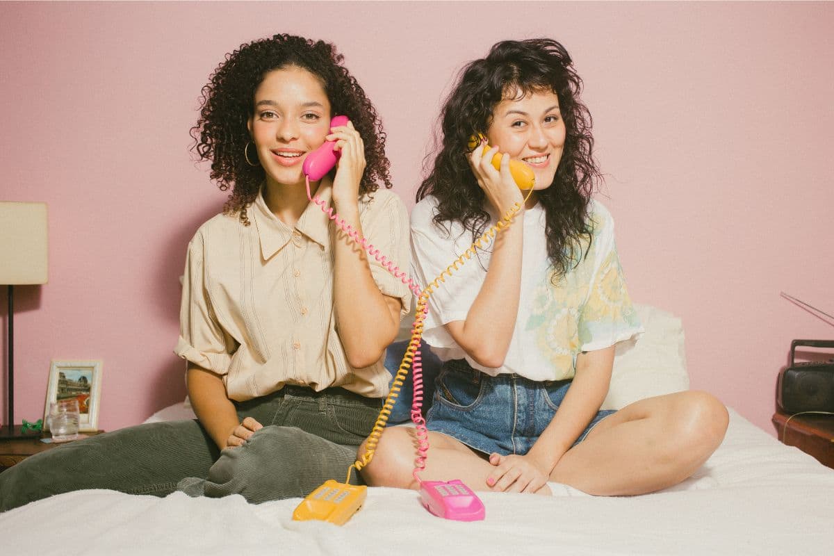 two girls talking on phones