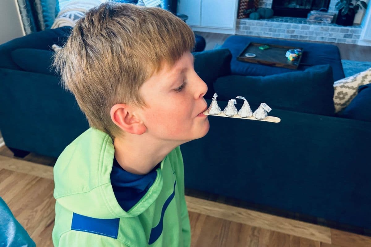 boy holding candy kisses on craft stick 