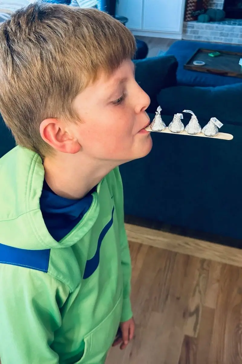 boy holding candy kisses on craft stick