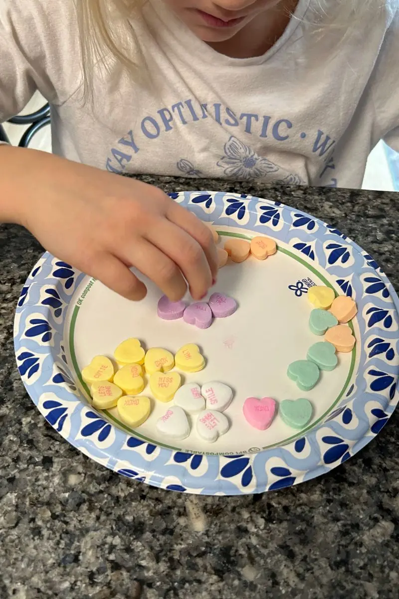 girl sorting candy hearts