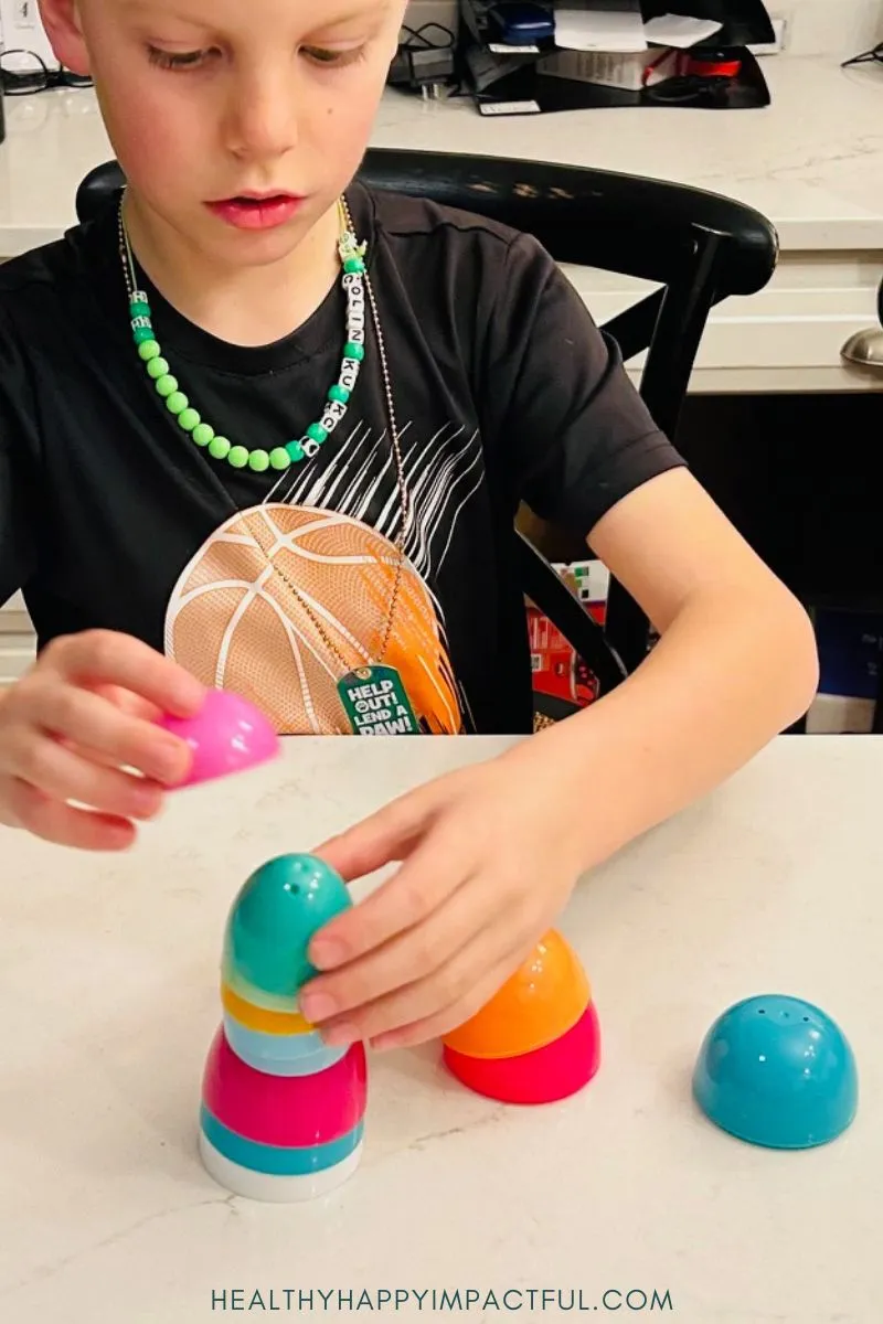 kid stacking plastic eggs; easy minute to win it games