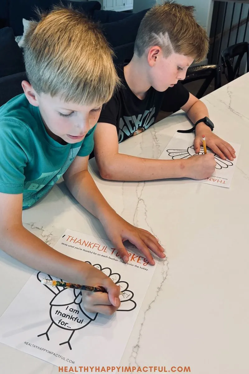 boys writing gratitude on their thankful turkey