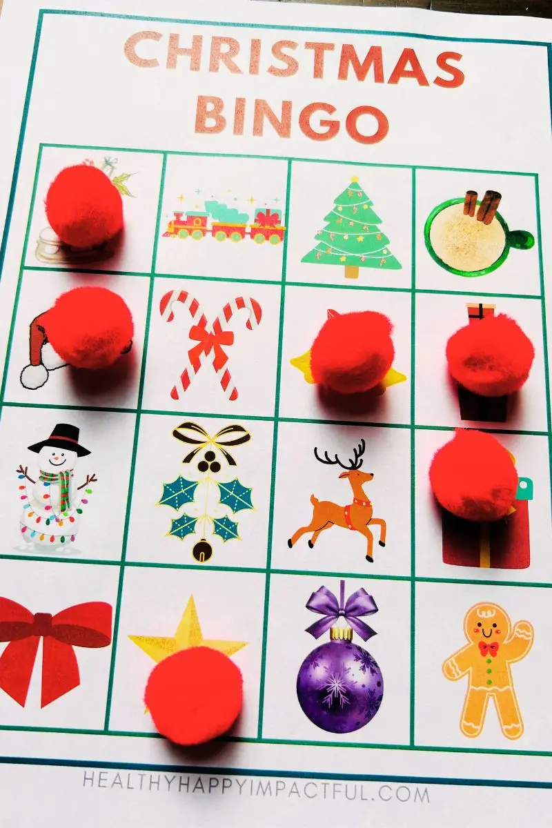 Christmas bingo printable game with red pom poms as markers
