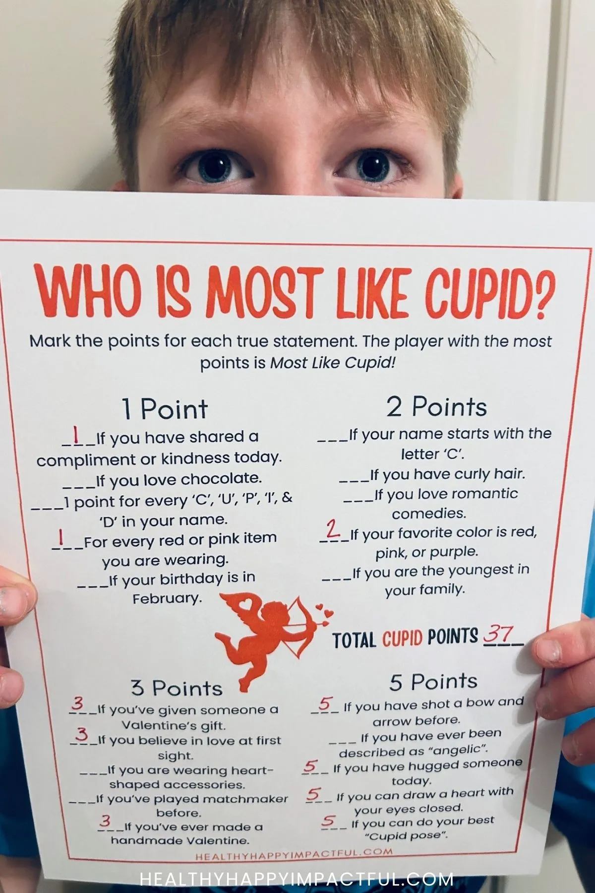 boy holding who is most like cupid game sheet
