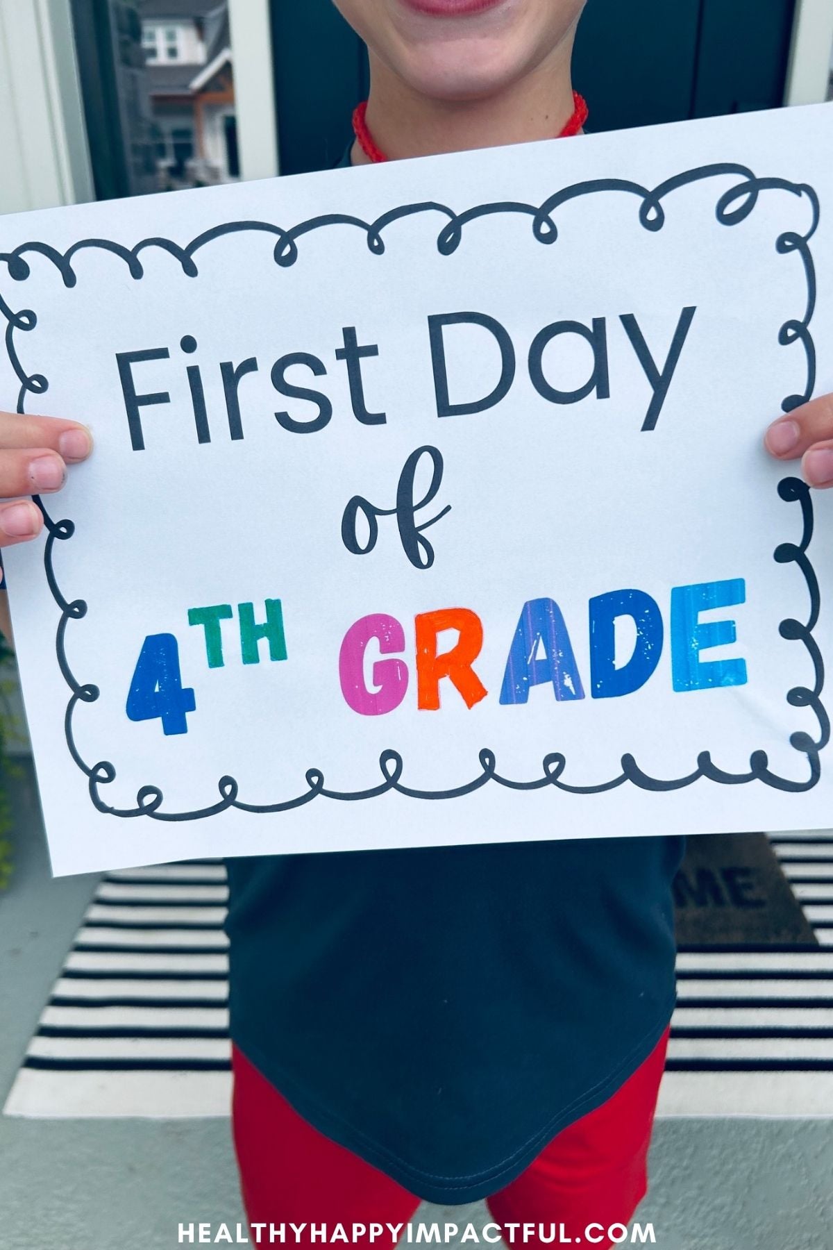 boy hold a first day of 4th grade sign